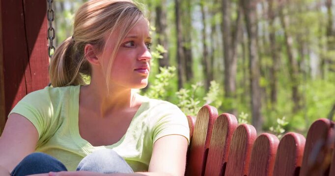 Girl sitting on porch bench thinking 4k

