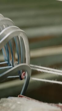 Textile factory weaving close up of automated machine parts releasing woven fabric