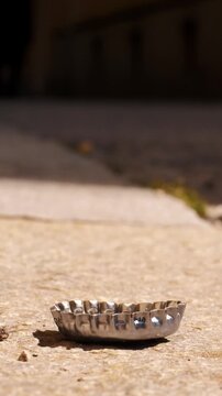 Discarded Bottle Cap on Urban Sidewalk. Detail of City Pollution