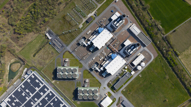 Aerial view of the Trianel Gaskraftwerk Hamm power plant featuring industrial buildings, cooling towers, and solar panels surrounded by green fields in Hamm, Nordrhein-Westfalen, Germany.