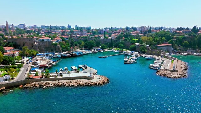 Drone view of Antalya, Turkey, Kaleici Marina and harbour. Boats, breakwater, blue water and city coastline create a scenic travel scene.