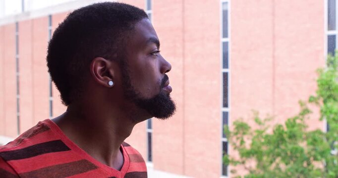 Young man looking out window tilt shot 4k
