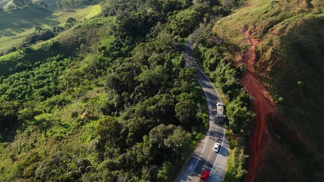 Drone capturando o movimento de autom&oacute;veis  estrada sinuosa entre morros da Serra da Mantiqueira.	
