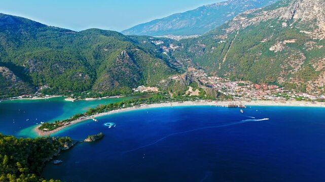 Drone view of Oludeniz Blue Lagoon, Turkey coastline. Blue water, forested hills and mountains create a peaceful summer travel scene.