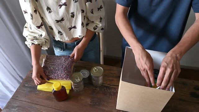 People preparing food and supplies for donation box
