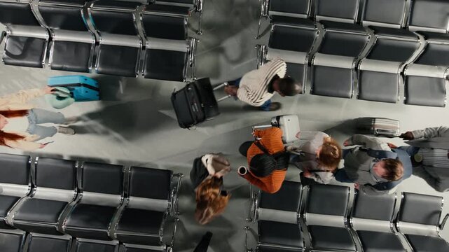 Walking, rows of empty seats and travelers in airport terminal. Navigating air transportation hub, trolleys and Passengers doing international transit, top down view shot