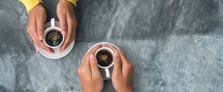 Banner Close up Hands holding coffee cup. Couple lover drinking black cup of coffee together. Banner Top view hands two people happy cafe coffee shop. Espresso shot with copy space