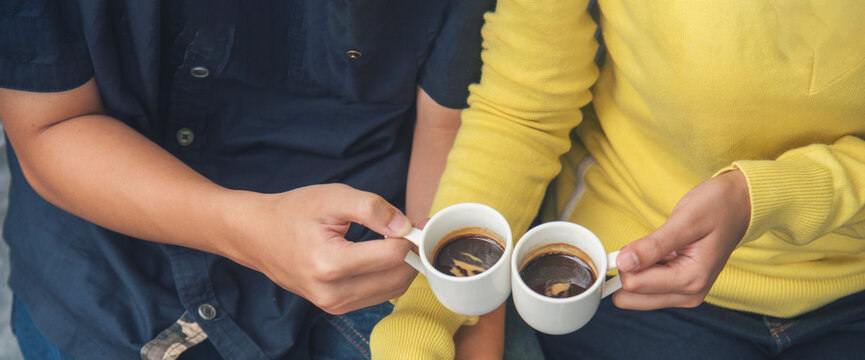 Banner Close up Hands holding coffee cup. Couple lover drinking black cup of coffee together. Banner Top view hands two people happy cafe coffee shop. Espresso shot with copy space