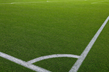 Obraz premium Corner kick area on a green artificial turf soccer field with white painted lines, empty football pitch for sports competition and athletic training background