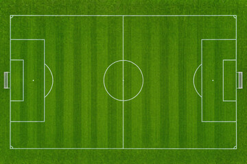 Aerial view of a green soccer field with white markings and mowed grass stripes, top down perspective of a football pitch for sports competition and athletic recreation © Patrick