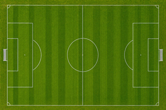 Aerial top down view of a green soccer field with white markings and goals, football pitch for sports competition and athletic recreation background