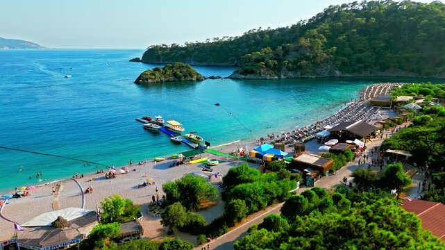 Drone view of Oludeniz Blue Lagoon, Turkey bay. Turquoise water, green headland and small boats create a peaceful Mediterranean scene.