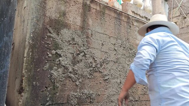 Plastering a brick cistern wall with cement mortar