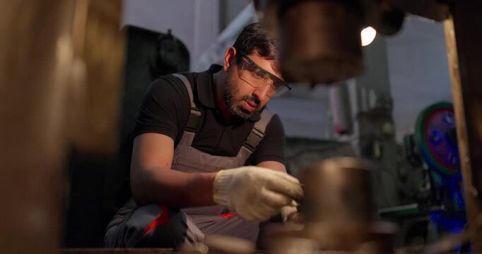 Technician Inspecting Precision Metal Component in Industrial Workshop