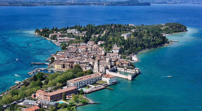 Aerial view of Scaligero Castle and the historic town center on the Sirmione peninsula surrounded by the turquoise waters of Lake Garda Sirmione, Lombardy, Italy.