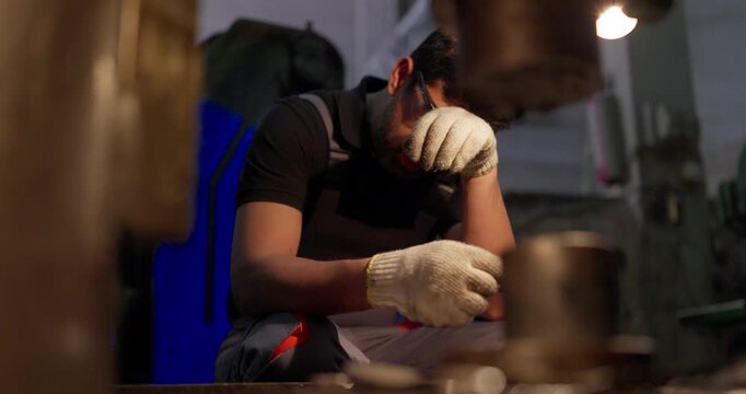 Technician Inspecting Precision Metal Component in Industrial Workshop