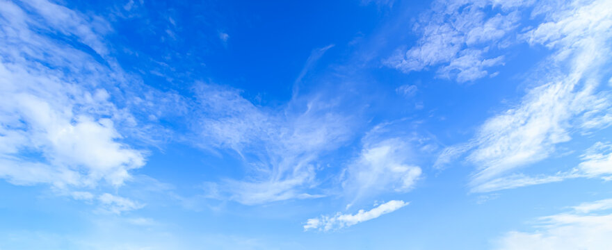 Panoramic vibrant blue sky background with soft white clouds and bright daylight for natural backdrop and clean outdoor design