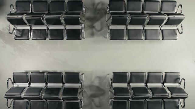 Walking, top down view and crowd in busy airport sitting on chairs. Waiting on benches, high angle shot and passengers navigating chaotic transit hub environment before departure during flight layover