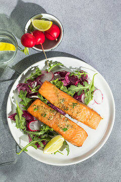Salmon. Fried salmon steak with red radicchio cabbage, radish and arugula.