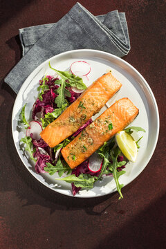 Salmon. Fried salmon steak with red radicchio cabbage, radish and arugula.