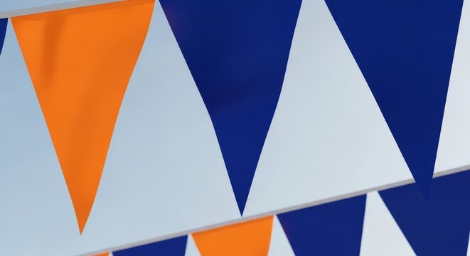 A detailed close-up of triangular bunting flags in bold orange and deep blue, creating a striking complementary color contrast against a clear sky, event, repetitive, close-up