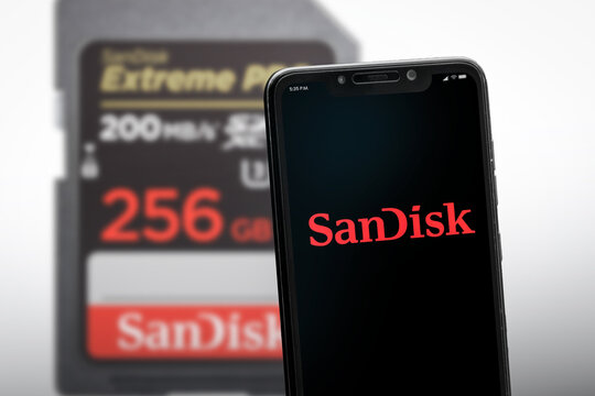 Cali, Colombia - May 4 2026: Smartphone displaying SanDisk logo beside microSD memory card