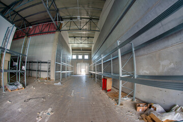 Naklejka premium Large unfinished industrial space featuring metal beam framework and raw warehouse construction interior details