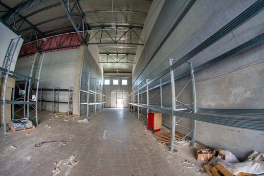Large unfinished industrial space featuring metal beam framework and raw warehouse construction interior details