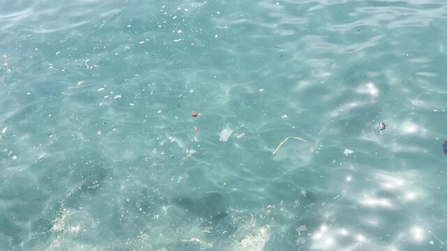 Plastic waste and microplastic debris polluting ocean water surface, environmental pollution concept