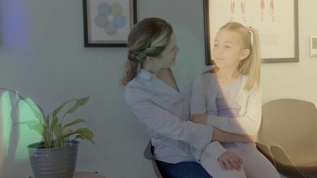 Girl speaking and relaxing in clinic, mom comforting, reassuring, light overlays drifting over them