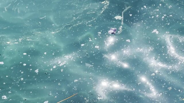 Plastic waste and microplastic debris polluting ocean water surface, environmental pollution concept