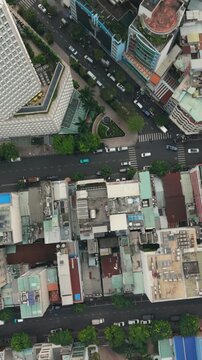 Vertical screen, Vietnam, Ho Chi Minh Aerial City Streets With Intersection And Dense Building Blocks, Moving Cars, Crosswalks And Sidewalk Activity, Urban Grid Perspective Revealing