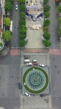 Vertical screen, Vietnam, Ho Chi Minh Aerial Roundabout Fountain Saigon Downtown Traffic Drone Overhead Captures Circular Fountain Center Of Plaza Surrounded By Moving Cars And Motorcycles