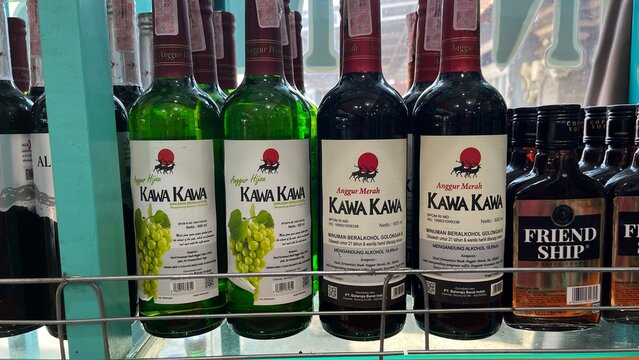 Kawa Kawa brand Anggur Hijau and Anggur Merah wine bottles on a retail store shelf with Friendship coffee vodka in Kuta Selatan district - Bali, Indonesia, March 24, 2023