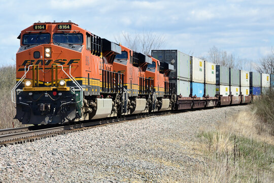 A trio of locomotives power a Burlington Northern Santa Fe container train as it passes through rural north central Illinois.