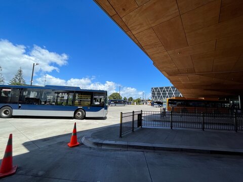Auckland Airport bus terminal featuring Metro Airportlink transit vehicles and modern transport infrastructure architecture on a sunny day - Auckland, New Zealand, February 07, 2023