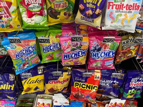 Selection of assorted candy and chocolate packets at a Break Time convenience store including Hi-Chew, Cadbury, and Haribo products - Auckland, New Zealand, February 07, 2023