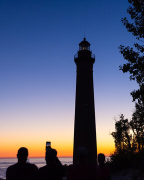 People watching Big Sable Point Lighthouse at sunset