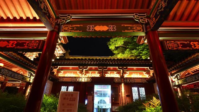 Night view of traditional Chinese courtyard gate tower with painted dougong bracket sets and wooden architecture
