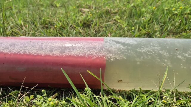 Water Flowing Through Joint Connection of White and Red PVC Pipes