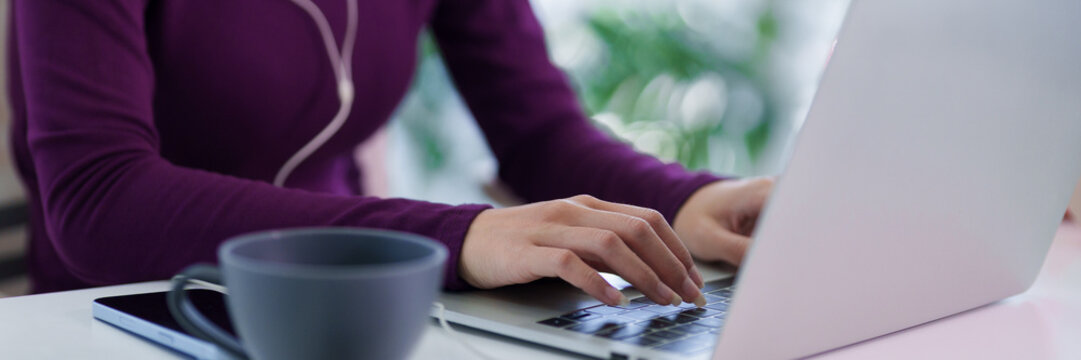 asian women working remotely from home office using laptop computer typing on keyboard with coffee cup on desk hybrid work lifestyle concept morning
