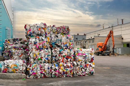 Pressed PET plastic bottles into briquettes, stored in a storage facility at a waste processing and sorting plant.