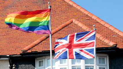 Naklejka premium Rainbow Pride Flag and Union Jack Flying Together in Brighton England