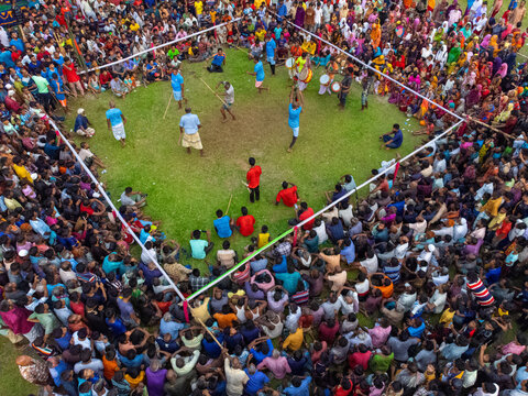 Nilphamari, Bangladesh - 01 May 2026: Aerial view of a traditional Lathi Khela stick fighting performance with a large crowd of spectators gathered around a grassy arena.