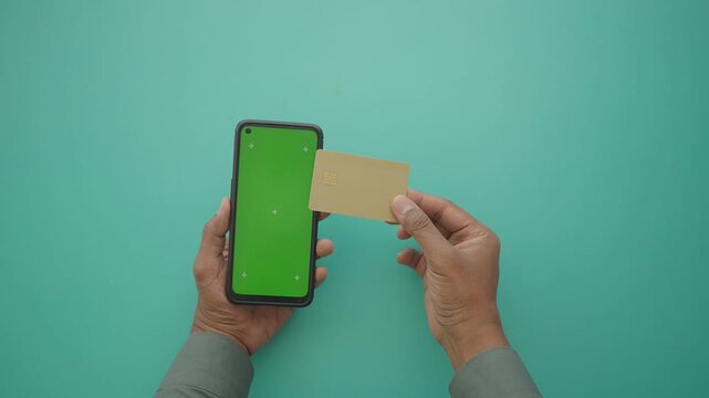 Hands Holding Green Screen Smartphone and Credit Card, NFC payment concept 