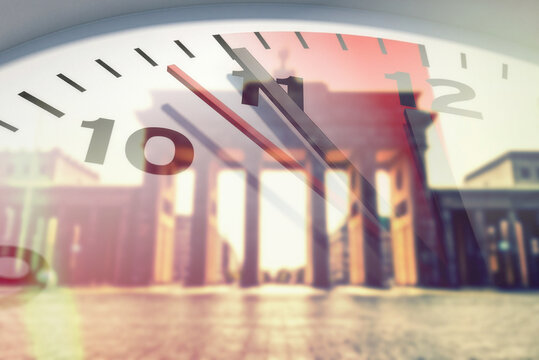 Brandenburger Tor in Berlin und eine Uhr, die 5 vor 12 zeigt und auf die Dringlichkeit der Reformen und Ver&auml;nderungen hinweist
