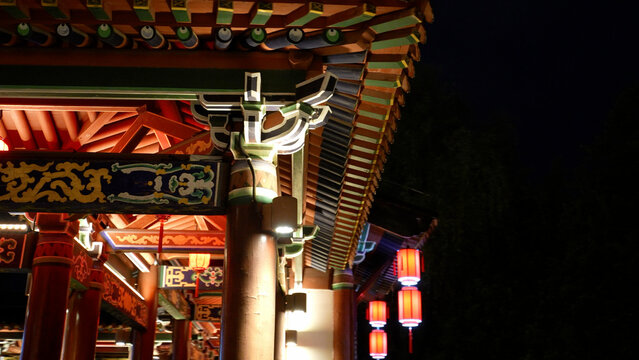 Traditional Chinese architectural eaves and dougong brackets with colorful paintings illuminated at night