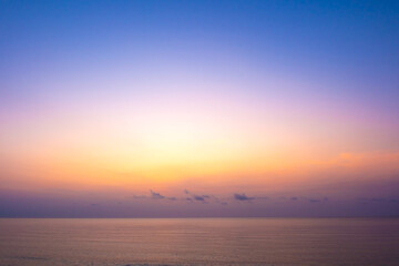 Obraz premium nature sky breathtaking golden sunset over a calm ocean, with the entire sky and water bathed in brilliant shades of yellow and orange. Streaky clouds enhance the dramatic display 