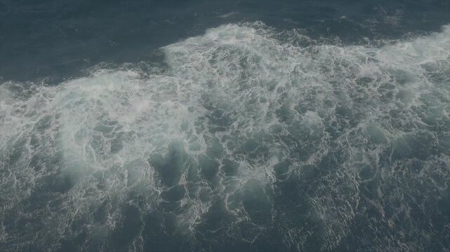 Close view of turbulent sea water with white foam patterns created by boat movement