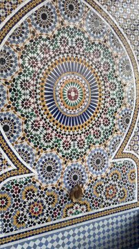 Detailed close up of colorful Moroccan zellige mosaic featuring symmetrical geometric patterns and ornate craftsmanship